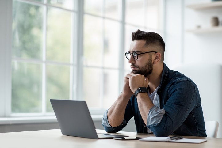 A man researching the differences between restricted stock units (RSUs) and restricted stock awards (RSAs).